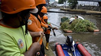 Sejumlah petugas Badan Penanggulangan Bencana Daerah (BPBD) DKI Jakarta menarik tumpukan sampah saat kerja bakti gabungan di Kali Ciliwung, Jakarta, Kamis (10/11/2022).[ANTARA FOTO/Sulthony Hasanuddin/YU]