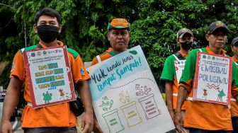Sejumlah petugas Dinas Lingkungan Hidup DKI Jakarta membawa poster kampanye lingkungan sehat saat Kerja Bakti Gabungan di Kali Ciliwung, Jakarta, Kamis (10/11/2022). [ANTARA FOTO/Sulthony Hasanuddin/YU]