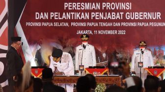 Menteri Dalam Negeri Tito Karnavian (kiri) menyaksikan penandatanganan berita acara pelantikan Penjabat Gubernur Provinsi Papua Selatan Apolo Safanpo (kedua kiri), Pj Gubernur Papua Pegunungan Nikolaus Kondomo (kedua kanan), dan Pj Gubernur Papua Tengah Ribka Haluk (kanan) di Kantor Kemendagri, Jakarta, Jumat (11/11/2022). [ANTARA FOTO/Indrianto Eko Suwarso/nz]