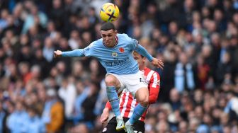 Gelandang Manchester City Phil Foden menyundul bola saat pertandingan sepak bola Liga Premier Inggris antara Manchester City dan Brentford di Stadion Etihad, Manchester, Inggris, Sabtu (12/11/2022). [Oli SCARFF / AFP]