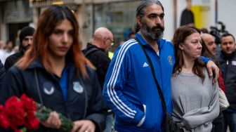  Orang-orang membawa bungan untuk para korban di lokasi ledakan bom di Jalan Istiklal, Istanbul, Turki, Senin (14/11/2022). [Yasin AKGUL/AFP]
