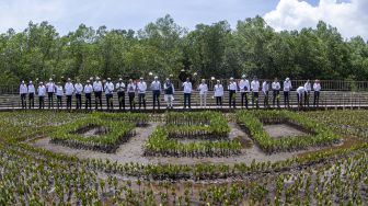 Presiden Joko Widodo (kedua belas kanan) bersama para kepala negara/kepala pemerintahan negara anggota G20 dan pimpinan organisasi internasional mengangkat pacul usai menanam mangrove saat rangkaian KTT G20 Indonesia di Taman Hutan Raya, Ngurah Rai, Denpasar, Bali, Selasa (16/11/2022). [ANTARA FOTO/Media Center G20 Indonesia/Sigid Kurniawan/wsj].