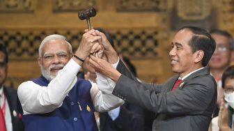 Presiden Joko Widodo (kanan) menyerahkan palu kepemimpinan G20 kepada Perdana Menteri India Narendra Damodardas Modi (kiri) pada penutupan KTT G20 Indonesia 2022 di Nusa Dua, Bali, Rabu (16/11/2022). [ANTARA FOTO/Media Center G20 Indonesia/M Risyal Hidayat/nym].