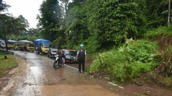 Petugas Badan Penanggulangan Bencana Daerah (BPBD) Banten menyetop kendaraan yang akan melintasi area longsor di Kampung Cikoak, Cilowong, Serang, Banten, Kamis (17/11/2022).[ANTARA FOTO/Asep Fathulrahman/hp].