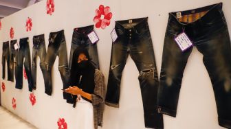 Pengunjung melihat produk-produk denim yang dipajang dalam pameran Wall of Fades di Pondok Indah Mall (PIM) 3, Jakarta Selatan, Sabtu (19/11/2022). [Suara.com/Alfian Winanto]