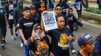 Keluarga Korban Tragedi Kanjuruhan bersama suporter Arema FC saat menggelar aksi unjuk rasa di depan Mabes Polri, Jakarta Selatan, Sabtu (19/11/2022). [Suara.com/Alfian Winanto]