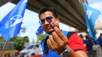 Simpatisan partai politik memberikan tanda cinta dengan salah satu jari bertinta usai melakukan pemungutan suara di salah satu pusat mengundi di Sekolah Kebangsaan Taman Maluri di Kuala Lumpur, Sabtu (19/11/2022). [ANTARA FOTO/ YU]
