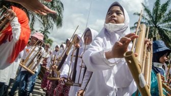 Pelajar Sekolah Dasar memainkan alat musik angklung secara bersama di halaman Gedung Sate, Bandung, Jawa Barat, Minggu (20/11/2022). [ANTARA FOTO/Novrian Arbi/nz]