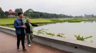 Pengunjung melihat pemandangan di Danau Archipelago di Taman Mini Indonesia Indah (TMII), Jakarta Timur, Minggu (20/11/2022). [Suara.com/Alfian Winanto]