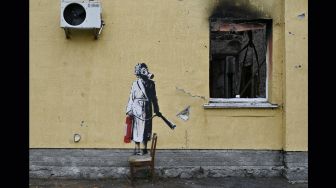 Grafiti yang dibuat oleh Banksy di dinding sebuah bangunan yang hancur di kota Gostomel, dekat Kyiv, Ukraina, Rabu (16/11/2022). [Genya SAVILOV / AFP]
