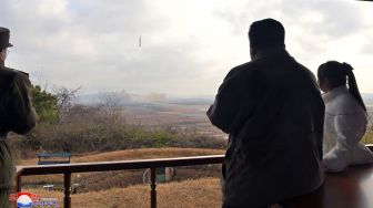 Pemimpin Korea Utara Kim Jong Un (kanan) bersama dengan putrinya melihat uji coba rudal balistik antarbenua (ICBM) baru "Hwasong Gun 17" di sebuah lokasi yang dirahasiakan di Korea Utara, Jumat (18/11/2022). [KCNA VIA KNS/AFP]