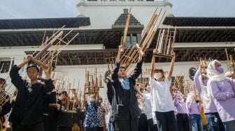 Pelajar Sekolah Dasar memainkan alat musik angklung secara bersama di halaman Gedung Sate, Bandung, Jawa Barat, Minggu (20/11/2022). [ANTARA FOTO/Novrian Arbi/nz]