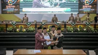 Perwakilan anggota tetap Pimpinan Pusat (PP) Muhammadiyah Busyro Muqoddas (kanan) dan Agung Danarto (kedua kanan) menyerahkan berkas penetapan kepada Ketua Umum Pimpinan Pusat (PP) Muhammadiyah terpilih 2022-2027 Haedar Nashir (kiri) dan Sekretaris Umum PP Muhammadiyah terpilih 2022-2027 Abdul Mu'ti (kedua kiri) saat acara Muktamar ke-48 Muhammadiyah di Edutorium KH Ahmad Dahlan UMS, Solo, Jawa Tengah, Minggu (20/11/2022). [ANTARA FOTO/Mohammad Ayudha/nz]
