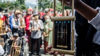 Pelajar memainkan alat musik angklung digital melalui gawai di halaman Gedung Sate, Bandung, Jawa Barat, Minggu (20/11/2022). [ANTARA FOTO/Novrian Arbi/nz]