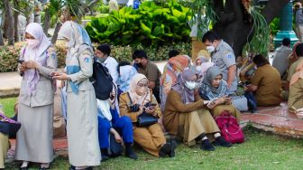 Sejumlan ASN di Balai Kota berkumpul di lapangan pasca gempa di Jakarta, Senin (21/11/2022). [Suara.com/Alfian Winanto]
