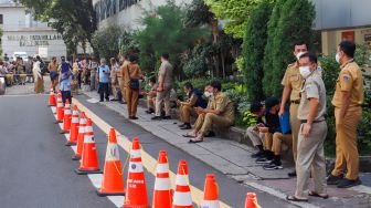 Sejumlan ASN di Balai Kota berkumpul di lapangan pasca gempa di Jakarta, Senin (21/11/2022). [Suara.com/Alfian Winanto]
