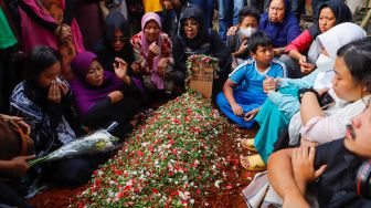 Keluarga dan pelayat berdoa di atas pusara Agung Yulianto alias Ki Joko Bodo di TPU Kober, Lubang Buaya, Jakarta Timur, Selasa (22/11/2022). [Suara.com/Alfian Winanto]