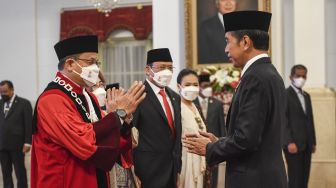 Presiden Joko Widodo (kanan) memberikan ucapan selamat kepada Hakim Konstitusi Guntur Hamzah (kiri) setelah resmi menjadi hakim konstitusi di Istana Negara, Jakarta, Rabu (23/11/2022). [ANTARA FOTO/Hafidz Mubarak]