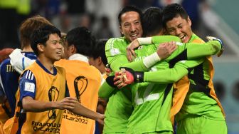 Para pemain Jepang melakukan selebrasi usai mengalahkan Jerman pada pertandingan sepak bola Grup E Piala Dunia 2022 antara Jerman dan Jepang di Stadion Internasional Khalifa di Doha, Qatar, Rabu (23/11/2022). [INA FASSBENDER/AFP]
