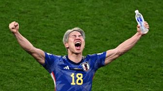 Penyerang Jepang Takuma Asano merayakan kemenangan timnya dalam pertandingan sepak bola Grup E Piala Dunia 2022 antara Jerman dan Jepang di Stadion Internasional Khalifa di Doha, Qatar, Rabu (23/11/2022). [Anne-Christine POUJOULAT / AFP]