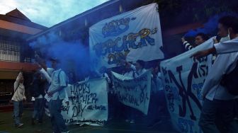 Sejumlah siswa meneriakan yel-yel dan menyalakan flare asap di sela Upacara Peringatan Hari Guru Nasional di SMK Bunda Kandung, Jakarta, Jumat (25/11/2022). [ANTARA FOTO/Indrianto Eko Suwarso/aww].