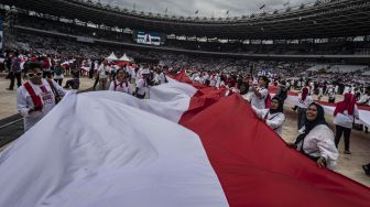 Sejumlah relawan membentangkan bendera Merah Putih dalam acara Gerakan Nusantara Bersatu : Satu Komando Untuk Indonesia di Stadion Utama Gelora Bung Karno, Jakarta, Sabtu (26/11/2022).[ANTARA FOTO/Aprillio Akbar/nym].