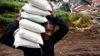 Relawan membawa logistik bantuan bencana gempa bumi untuk disalurkan di Sarampad, Kabupaten Cianjur, Jawa Barat, Sabtu (26/11/2022). [ANTARA FOTO/Yulius Satria Wijaya/hp]
