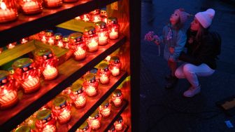 Penduduk setempat menyalakan lilin untuk memperingati para korban Holodomor 1932-1933 di Lviv, Ukraina, Sabtu (26/11/2022). [YURIY DYACHYSHYN / AFP]
