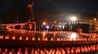 Penduduk setempat menyalakan lilin untuk memperingati para korban Holodomor 1932-1933 di Lviv, Ukraina, Sabtu (26/11/2022). [YURIY DYACHYSHYN / AFP]
