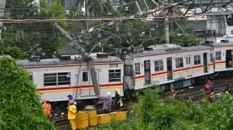 Sejumlah petugas berupaya mengevakuasi rangkaian kereta rel listrik (KRL) Commuterline KA 5144C yang anjlok dan tertimpa tiang listrik di perlintasan Stasiun Kampung Bandan, Jakarta, Sabtu (26/11/2022). [ANTARA FOTO/Aditya Pradana Putra/hp]
