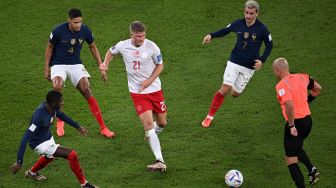 Penyerang Denmark Andreas Cornelius dihadang oleh bek Prancis Dayot Upamecano, Raphael Varane dan penyerang Prancis Antoine Griezmann selama pertandingan sepak bola Grup D Piala Dunia 2022 antara Prancis dan Denmark di Stadion 974 di Doha, Qatar, Sabtu (26/11/2022). [Anne-Christine POUJOULAT / AFP]
