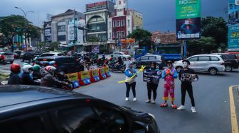 Anggota badut Depok menggalang dana untuk korban gempa bumi Cianjur di Margonda, Depok, Jawa Barat, Senin (28/11/2022). [Suara.com/Alfian Winanto]