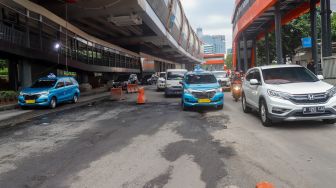 Kendaraan melintasi jalan rusak di sekitar Pembangunan Stasiun LRT, Jalan Rasuna Said, Jakarta Selatan, Rabu (30/11/2022). [Suara.com/Alfian Winanto]