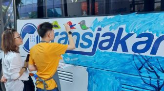 Sejumlah anak berkebutuhan khusus melukis mural bus TransJakarta di Kantor PT TransJakarta, Cawang, Jakarta, Kamis (1/12/2022). [ANTARA/Yogi Rachman]