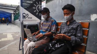 Warga mengisi daya gawainya di stasiun pengisi daya listrik bertenaga surya di kawasan Dukuh Atas, Jakarta Pusat, Senin (14/11/2022). [Suara.com/Alfian Winanto]