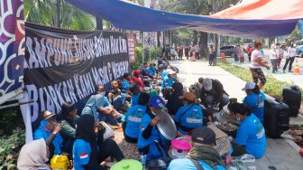 Warga Kampung Bayam berada di dalam tenda saat menggelar aksi unjuk rasa di depan Balai Kota Jakarta, Kamis (1/12/2022). [Suara.com/Alfian Winanto]