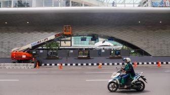 Sejumlah kendaraan melintas di dekat proyek revitalisasi Halte Tosari di Jalan Jenderal Sudirman, Jakarta Pusat, Jumat (2/12/2022). [Suara.com/Alfian Winanto]