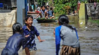 Warga menggunakan perahu saat melintasi banjir luapan Sungai Citarum di Kampung Bojongasih, Dayeuhkolot, Kabupaten Bandung, Jawa Barat, Sabtu (3/12/2022). [ANTARA FOTO/Raisan Al Farisi].
