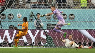 Kiper Belanda Andries Noppert dan bek Belanda Denzel Dumfries gagal menahan bola sehingga tercipta gol saat pertandingan sepak bola babak 16 besar Piala Dunia 2022 antara Belanda dan AS di Khalifa International Stadium, Doha, Qatar, Sabtu (3/12/2022). [ADRIAN DENNIS / AFP]
