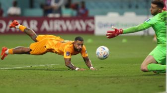 Penyerang Belanda Memphis Depay berusaha menyundul bola saat pertandingan sepak bola babak 16 besar Piala Dunia 2022 antara Belanda dan AS di Khalifa International Stadium, Doha, Qatar, Sabtu (3/12/2022).[ADRIAN DENNIS / AFP]