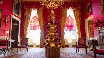 Dekorasi Natal terlihat di Red Room saat pratinjau media untuk Holidays 2022 di Gedung Putih di Washington DC, Amerika Serikat, Senin (28/11/2022). [Jim WATSON / AFP]