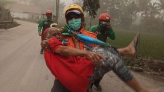 Petugas mengevakuasi seoarang warga saat Gunungapi Semeru meluncurkan Awan Panas Guguran (APG) di Lumajang, Jawa Timur, Minggu (4/12/2022). [ANTARA FOTO/Dok BNPB/Zk/YU]
