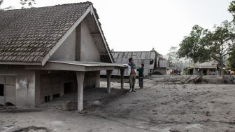 Warga beraktivitas di samping rumah yang terdampak awan panas guguran Gunung Semeru di Dusun Kajar Kuning, Desa Sumberwuluh, Lumajang, Jawa Timur, Senin (5/12/2022). Bencana awan panas guguran Gunung Semeru tersebut menyebabkan puluhan rumah penduduk rusak dan ratusan warga mengungsi. ANTARA FOTO/Umarul Faruq/nym.