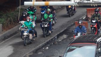Ojek online melintas di Jalan Rasuna Said, Jakarta Selatan, Selasa (6/12/2022). [Suara.com/Alfian Winanto]