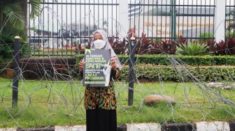 Massa saat menggelar aksi unjuk rasa menolak pengesahan KUHP di depan Gedung DPR RI, Senayan, Jakarta Pusat, Selasa (6/12/2022). [Suara.com/Alfian Winanto]