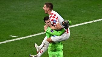 Gelandang Kroasia Mario Pasalic (kanan) merayakan dengan kiper Dominik Livakovic setelah melepaskan tendangan penalti kemenangan saat pertandingan sepak bola babak 16 besar Piala Dunia 2022 antara Jepang dan Kroasia di Stadion Al-Janoub di Al-Wakrah, selatan Doha, Qatar, Senin (5/12/2022). [Anne-Christine POUJOULAT / AFP]