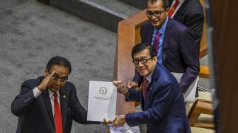 Menteri Hukum dan Hak Asasi Manusia Yasonna H Laoly menerima dokumen laporan Komisi III terkait RKUHP dari Ketua Komisi III Bambang Wuryanto (kiri) saat Rapat Paripurna DPR ke-11 masa persidangan II tahun 2022-2023 di Kompleks Parlemen, Senayan, Jakarta, Selasa (6/12/2022). [ANTARA FOTO/Galih Pradipta].