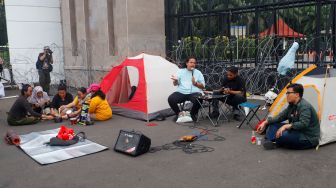 Massa saat menggelar aksi unjuk rasa menolak pengesahan KUHP di depan Gedung DPR RI, Senayan, Jakarta Pusat, Selasa (6/12/2022). [Suara.com/Alfian Winanto]