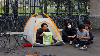 Massa saat menggelar aksi unjuk rasa menolak pengesahan KUHP di depan Gedung DPR RI, Senayan, Jakarta Pusat, Selasa (6/12/2022). [Suara.com/Alfian Winanto]