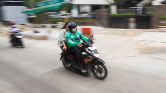 Ojek online melintas di Jalan Rasuna Said, Jakarta Selatan, Selasa (6/12/2022). [Suara.com/Alfian Winanto]